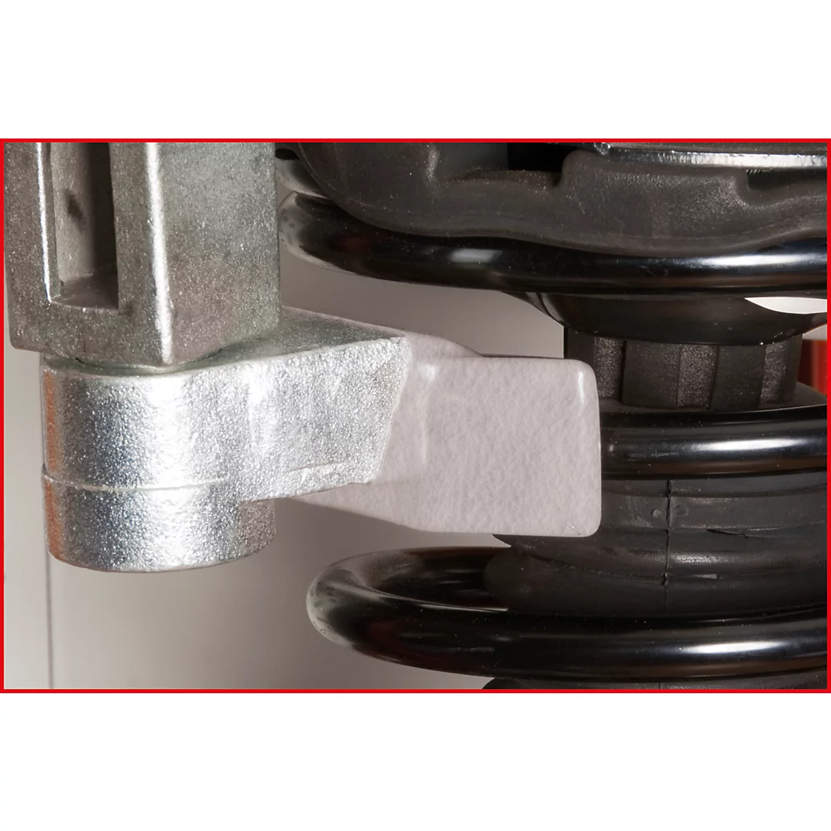 Nahaufnahme eines metallischen Mechanismus, der mit einer schwarzen Feder verbunden ist, Details